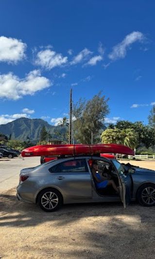 Kayaks loaded on top of rental car with soft foam racks
