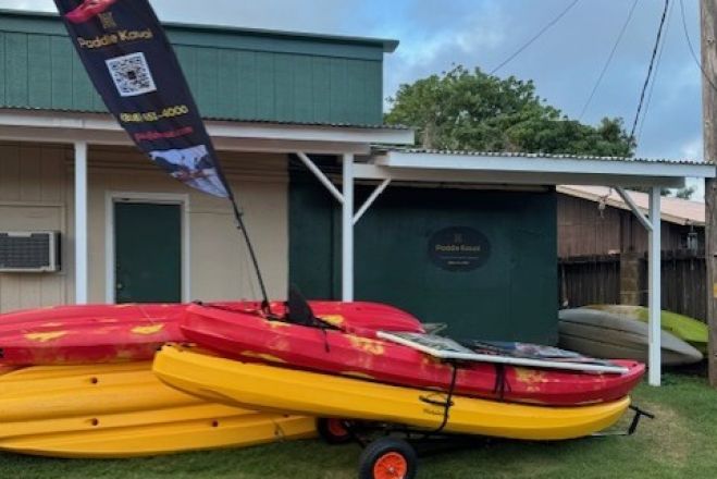 Vibrant kayaks stacked on a seaside rack at sunset in the Philippines, perfect for a serene adventure.